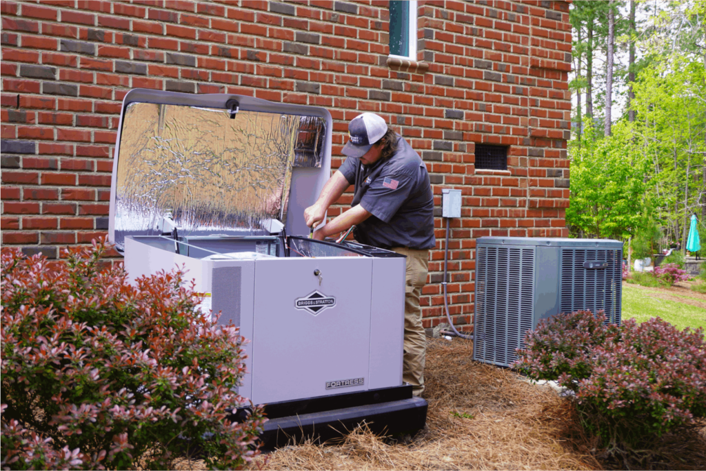 Technician working on generator outside a brick home, next to an HVAC unit.